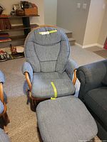 Front view of blue-cushioned wood glider rocker with matching footstool