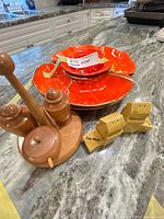 Overall lot: red platters, wooden condiment set, yellow grain-elevator shakers