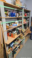 Full view of assembled concrete block and plywood shelving unit with four shelves
