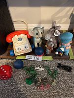 Entire lot on shelf including telephone, figurines, dice, balls, small plastic pieces