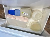 Drawer view showing two tall rectangular containers, medium square container, gelatin mold, spare lids