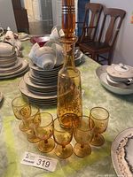 Full view of amber glass decanter with six matching liqueur glasses