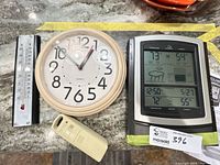 Overview of all four items: wireless weather station display, remote sensor, analog wall clock, metal thermometer