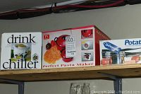 Boxes of three new housewares on a shelf: Drink Chiller, Perfect Pasta Maker, and Danesco Potato Ricer.