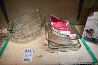 Photo showing 8 glass baking dishes stacked on a wooden surface with clear visibility of shapes and sizes.