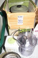 Shows coffee percolator in box with food processor base and juicer parts in front.