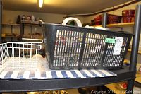 Plastic basket full of assorted tapes placed on a shelf