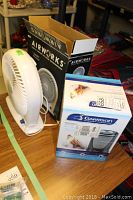 Photo of Garrison ceramic heater box and Airworks 12-inch fan on a table with boxes.