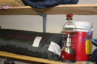 Photo showing the black StormShield tent bag on a shelf beside a red water cooler and GE electric lantern