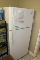 Front view of the white Kenmore refrigerator showing height and freezer on top.