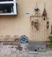Group shot showing trellis with chimes, planters, plaque, birdhouse