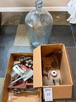 overall view of glass demijohn and two boxes of vintage kitchen items