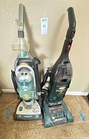Front view of both vacuums standing side by side