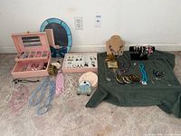 Overview of jewelry spread, showing necklaces, bracelets, watches, jewelry box and display stand