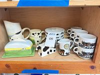 Shelf view showing pitcher, mugs, butter dish, shakers, bowls