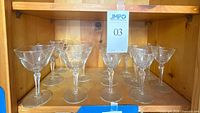 Shelf view of all 13 etched starburst stemmed glasses