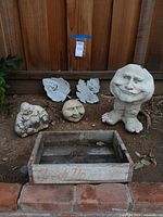 All six items grouped: planter statue, sphere, Buddha, two leaf plaques, 7 Up crate