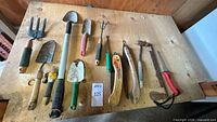 All twelve garden tools laid out on workbench