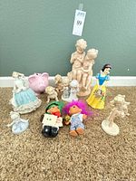 Group shot of all figurines, piggy bank, Snow White and trolls