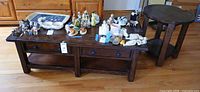 Rectangular coffee table with items on top and round end table beside it