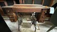 Front of Singer treadle cabinet showing drawers and cast-iron base