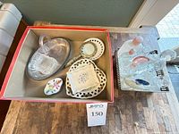 Overview of lot in box showing perfume bottles, oval tray, magnifier and dishes