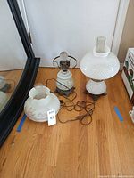 Two lamp bases, detached floral shade, cords, hobnail lamp visible