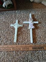 Close view of two wall crosses with ruler for scale