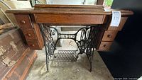 Front view of oak cabinet on Singer cast iron treadle base with six drawers