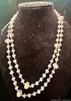 Full view of double-strand iridescent bead necklace on display bust