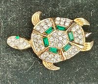 Front view of gold-tone turtle brooch showing rhinestone and crystal arrangement