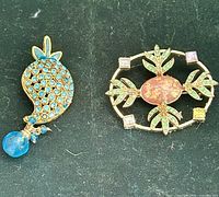 Both brooches front view showing designs and stones