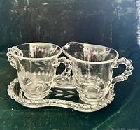 creamer and sugar bowl on matching tray showing overall pattern and bead edging