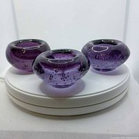Three purple glass tealight holders front view