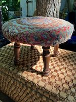 Full view of the round footstool showing knit rug top and wooden legs