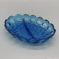 Top angled view of cobalt blue divided dish showing starburst base, divider, scalloped rim