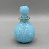 Front view of blue embossed glass perfume bottle with stopper