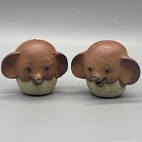 Front view of both elephant shakers showing faces and glaze coloration