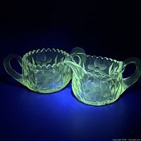 Creamer and sugar bowl glowing yellow-green under UV light