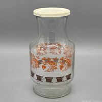 Front view of clear glass pitcher with floral graphics and lid