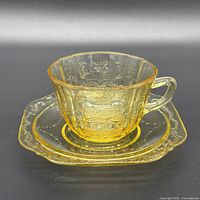 Side view of amber Madrid cup on saucer showing embossed pattern