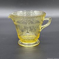 Left front view of amber Patrician Spoke creamer showing handle, spout, pedestal