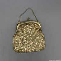 Front view of gold metal mesh evening bag showing chain handle and kiss-lock frame