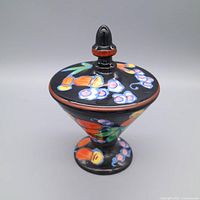 Jar with lid, angled top view highlighting floral painting and finial