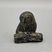 front view of ceramic owl perched on log