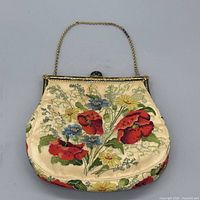 front view of handbag showing full floral embroidery and chain handle