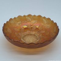 Top angled view of marigold carnival glass bowl showing iridescent finish and scalloped rim