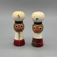 Front view of both wooden salt and pepper shakers showing faces, letters S and P, fabric accents