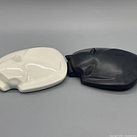 Both white and black ceramic cat figurines top view