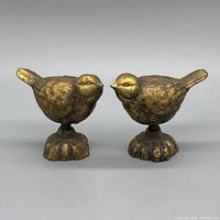 Front view of both cast iron bird figurines